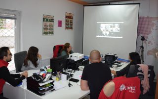 Učesnici obuke sede za stolom u kancelariji Caritasa Srbije