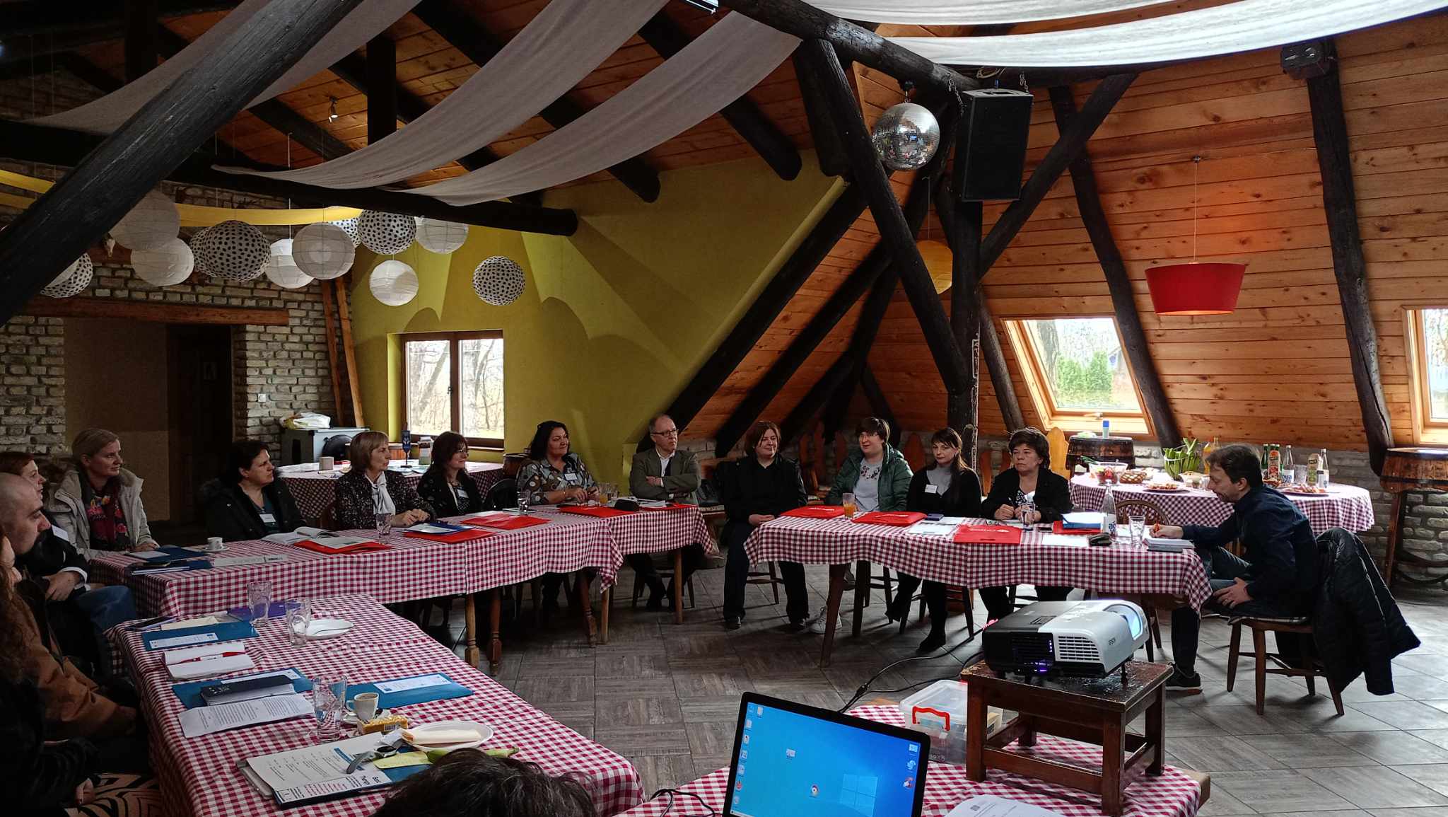 Svi učesnici susreta sede za stolom i slušaju izlaganje Jelene Ankić